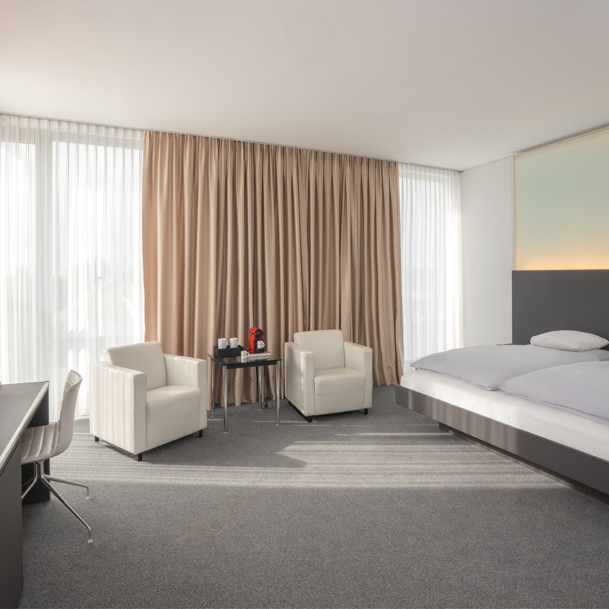 a room with a bed and chairs