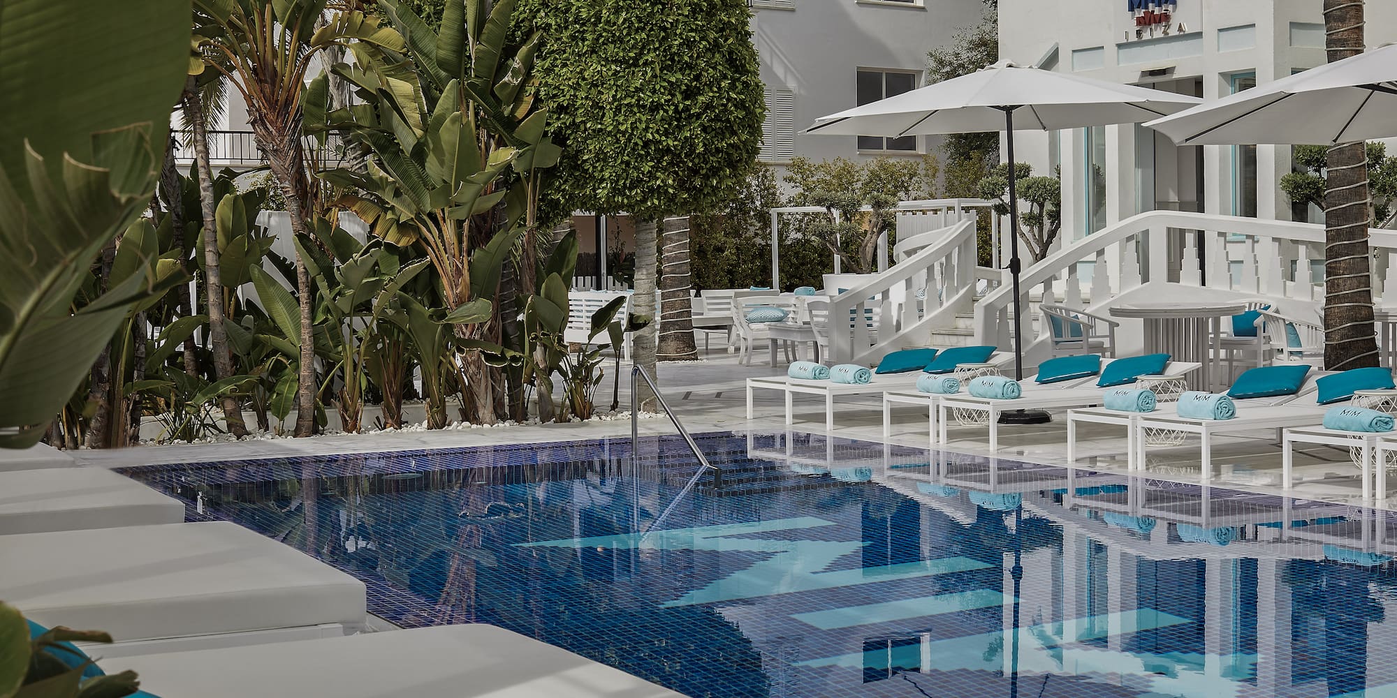 a pool with lounge chairs and umbrellas