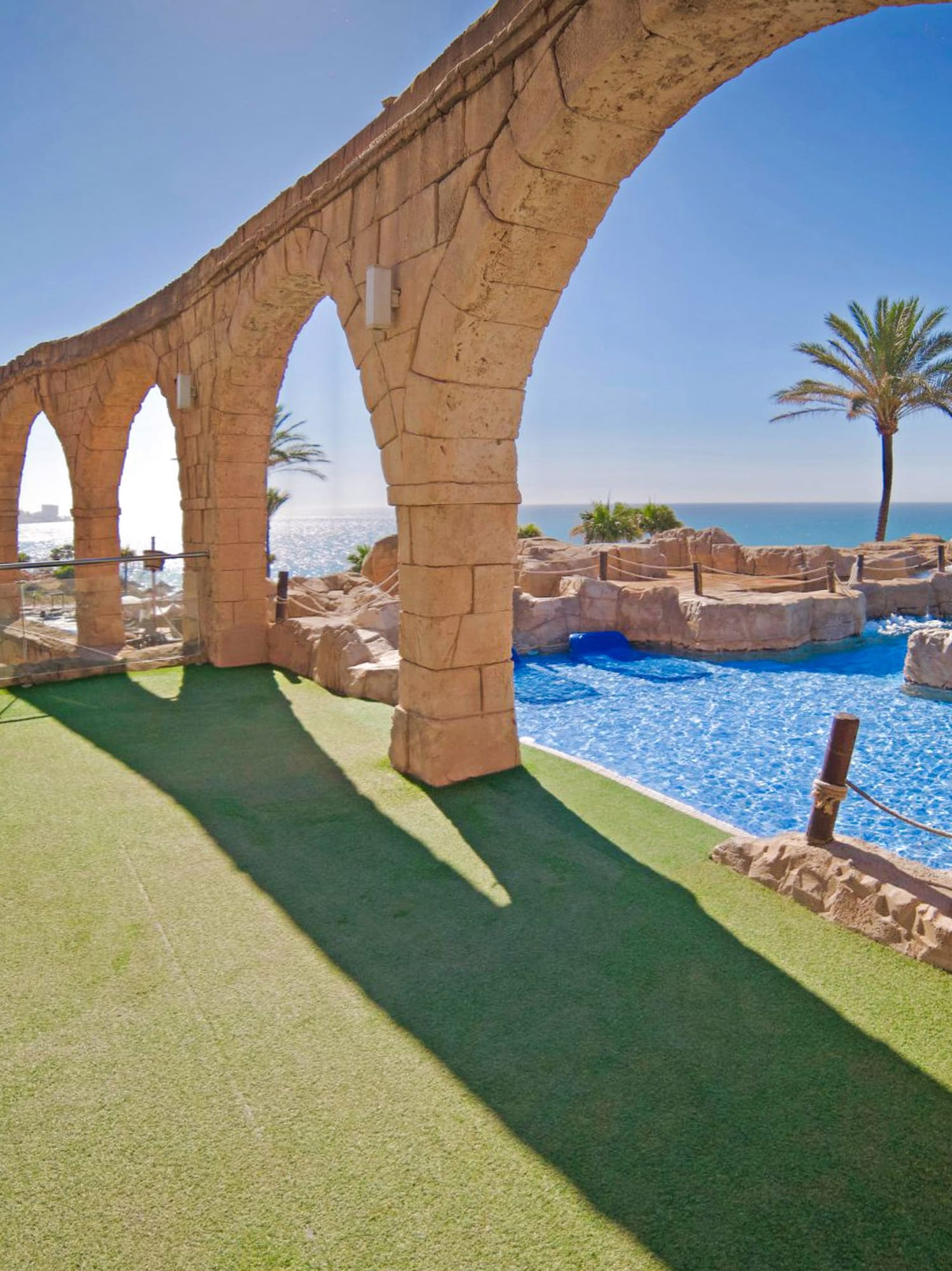 a pool with a stone arch over it