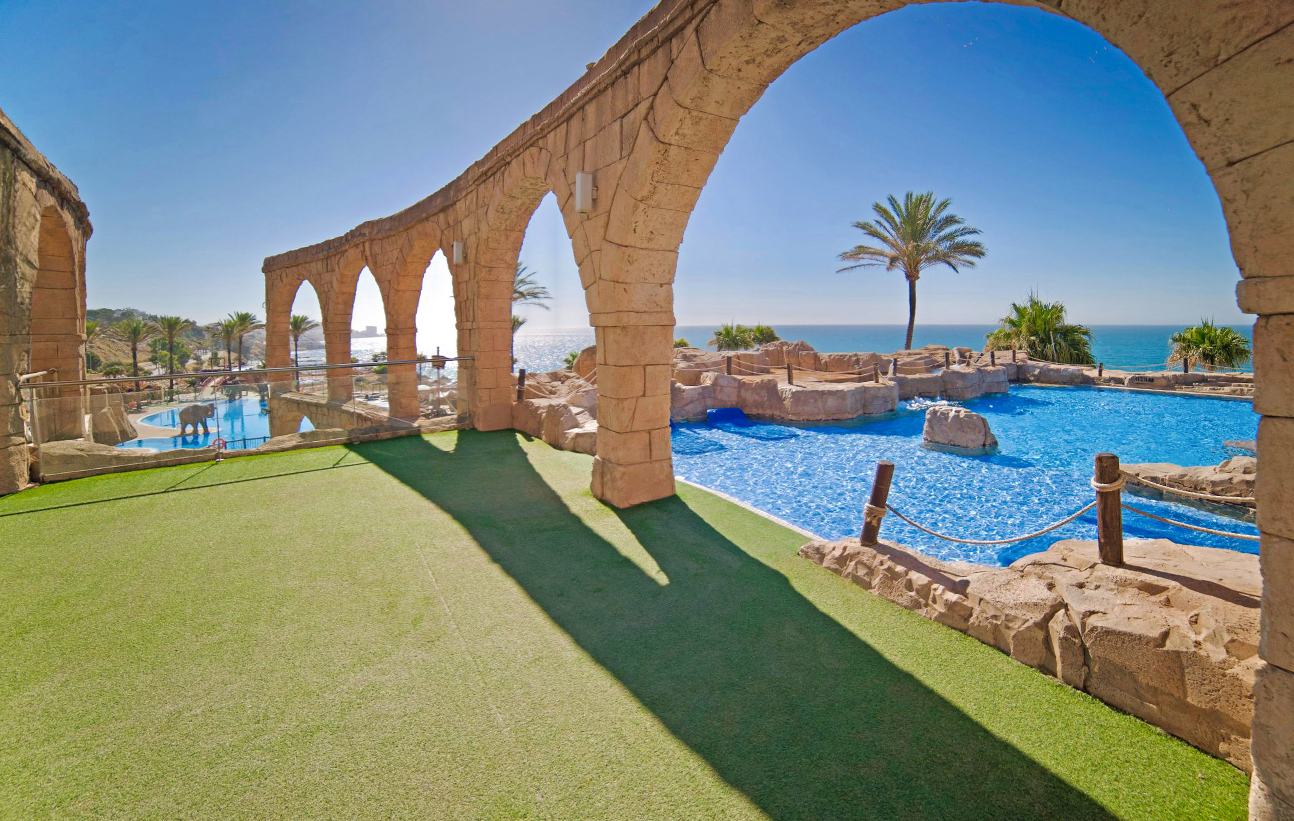 a pool with a stone arch over it