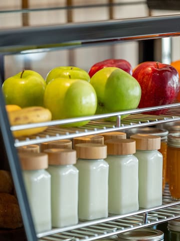 a glass display case with fruits and jars on shelves