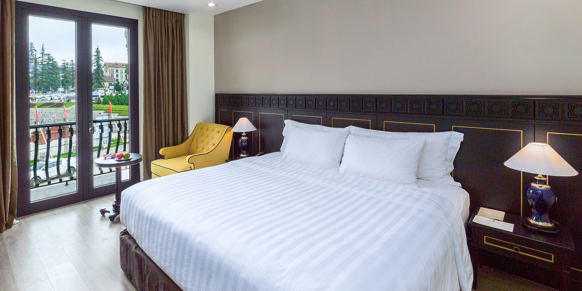 a bed with a chair and a table in a room with a lake