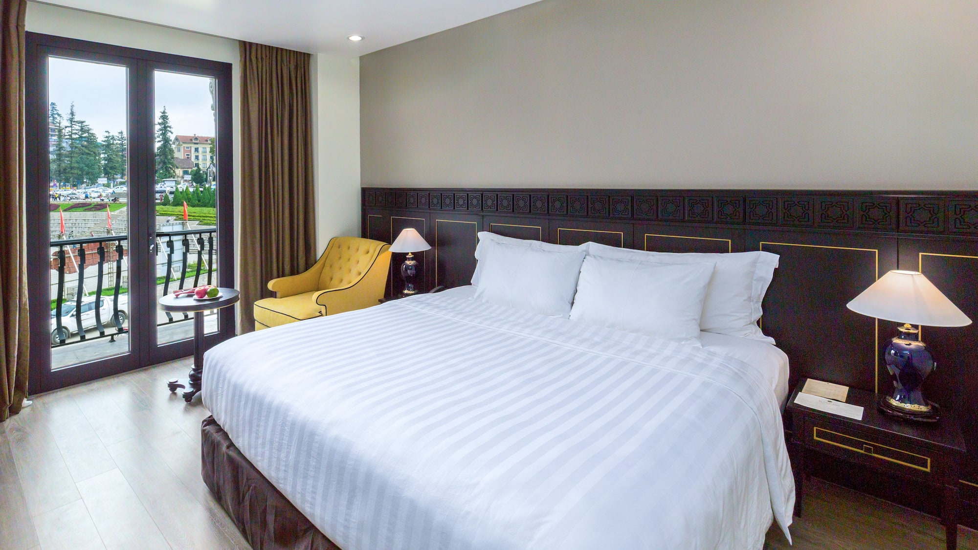 a bed with a chair and a table in a room with a lake