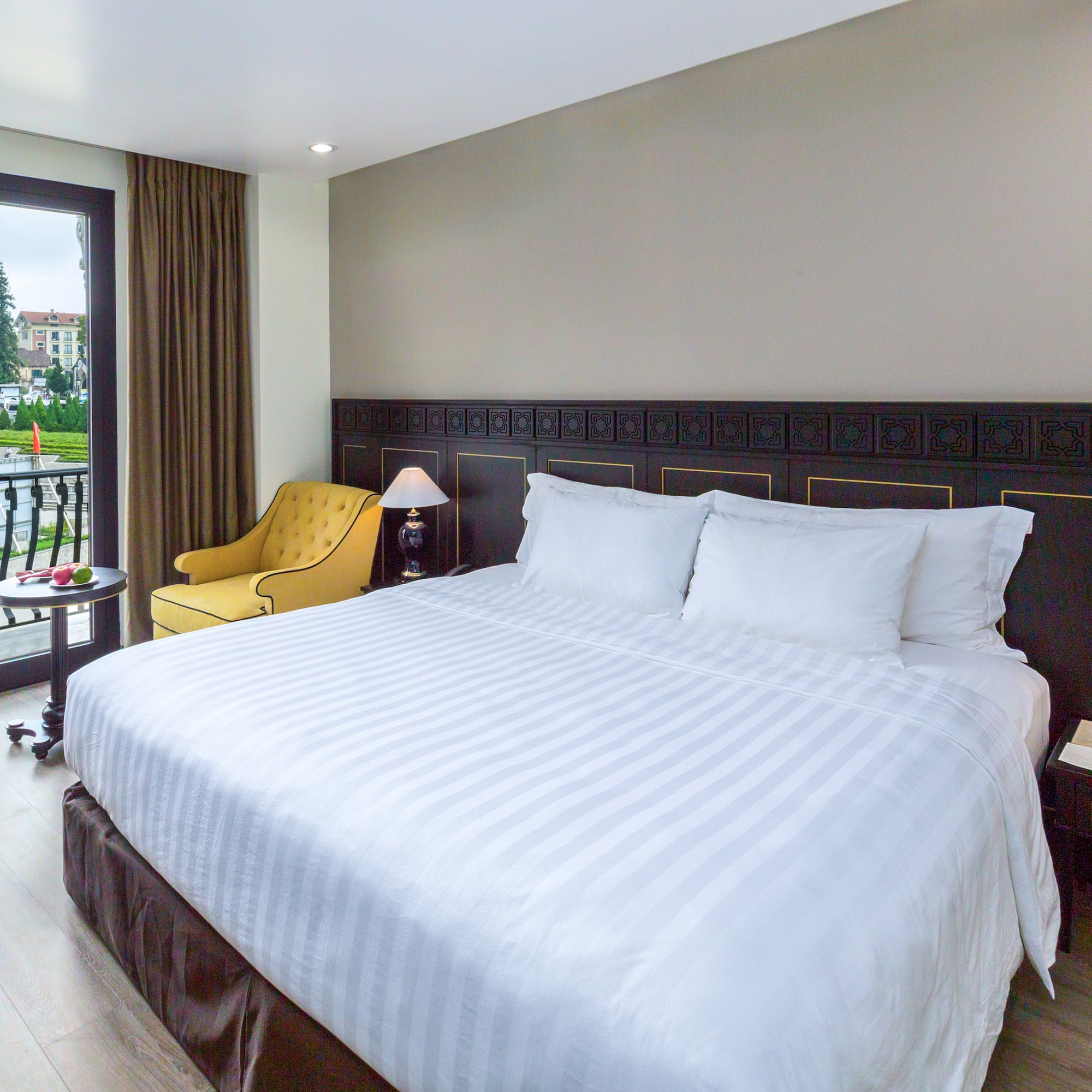 a bed with a chair and a table in a room with a lake