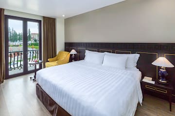 a bed with a chair and a table in a room with a lake