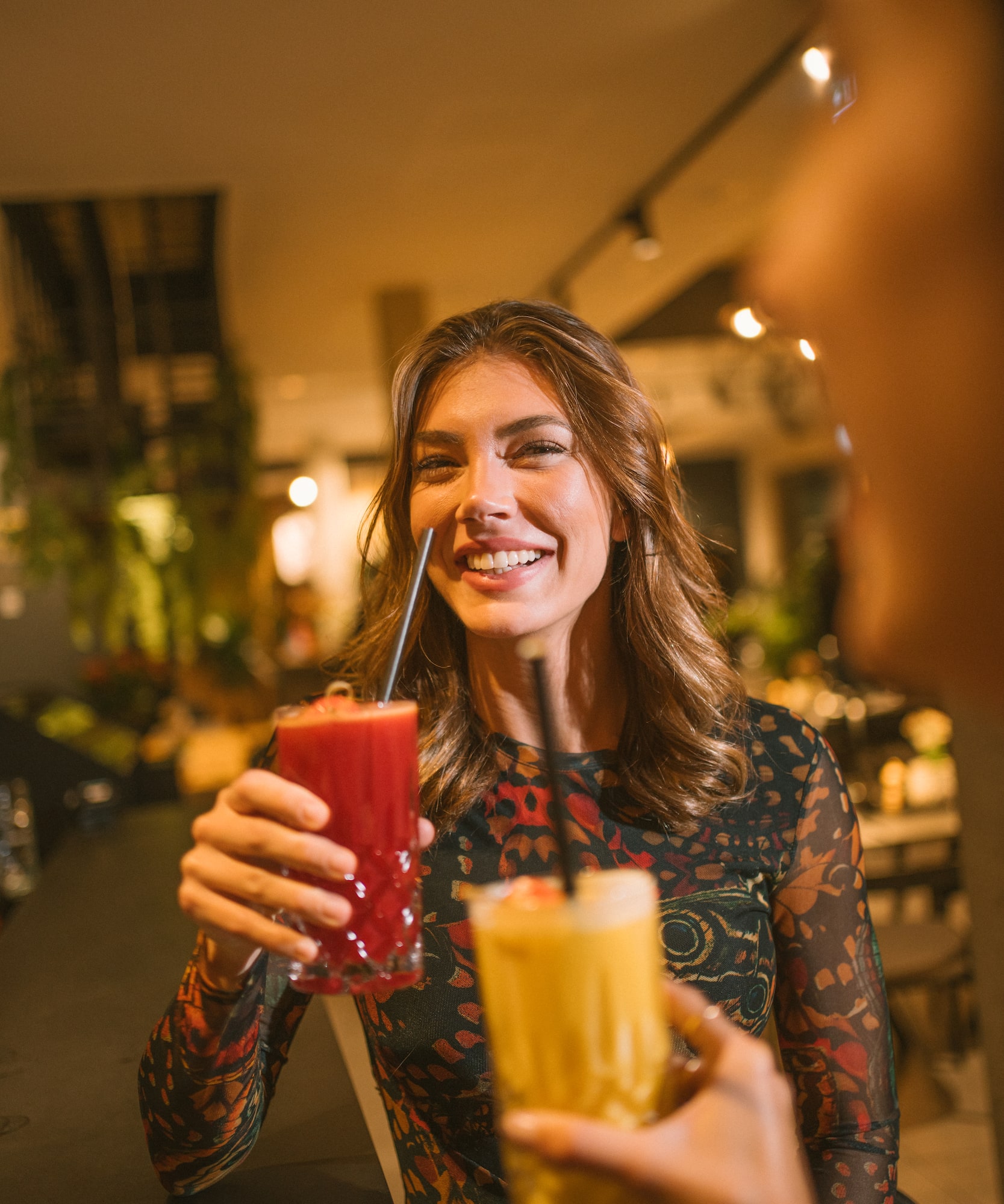 a woman holding a drink with straw