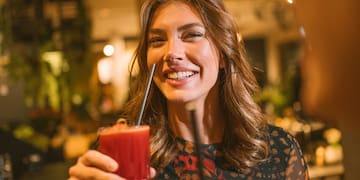 a woman holding a drink with straw