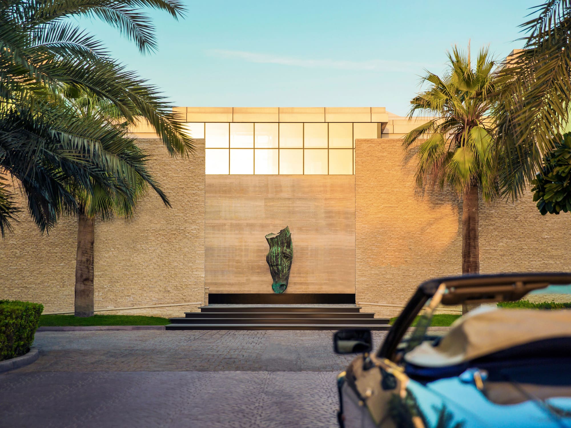 a car parked in front of a building with palm trees