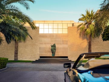 a car parked in front of a building with palm trees