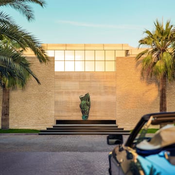a car parked in front of a building with palm trees
