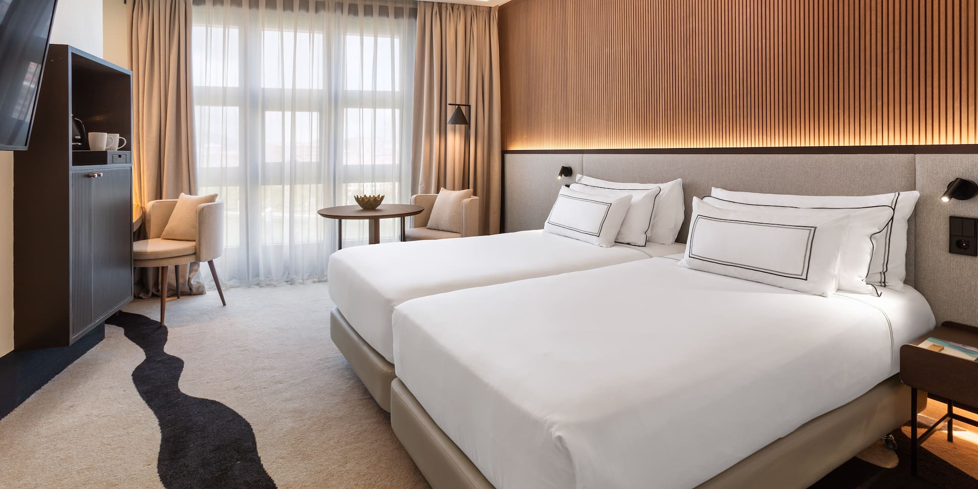 a room with two beds and a table and chairs