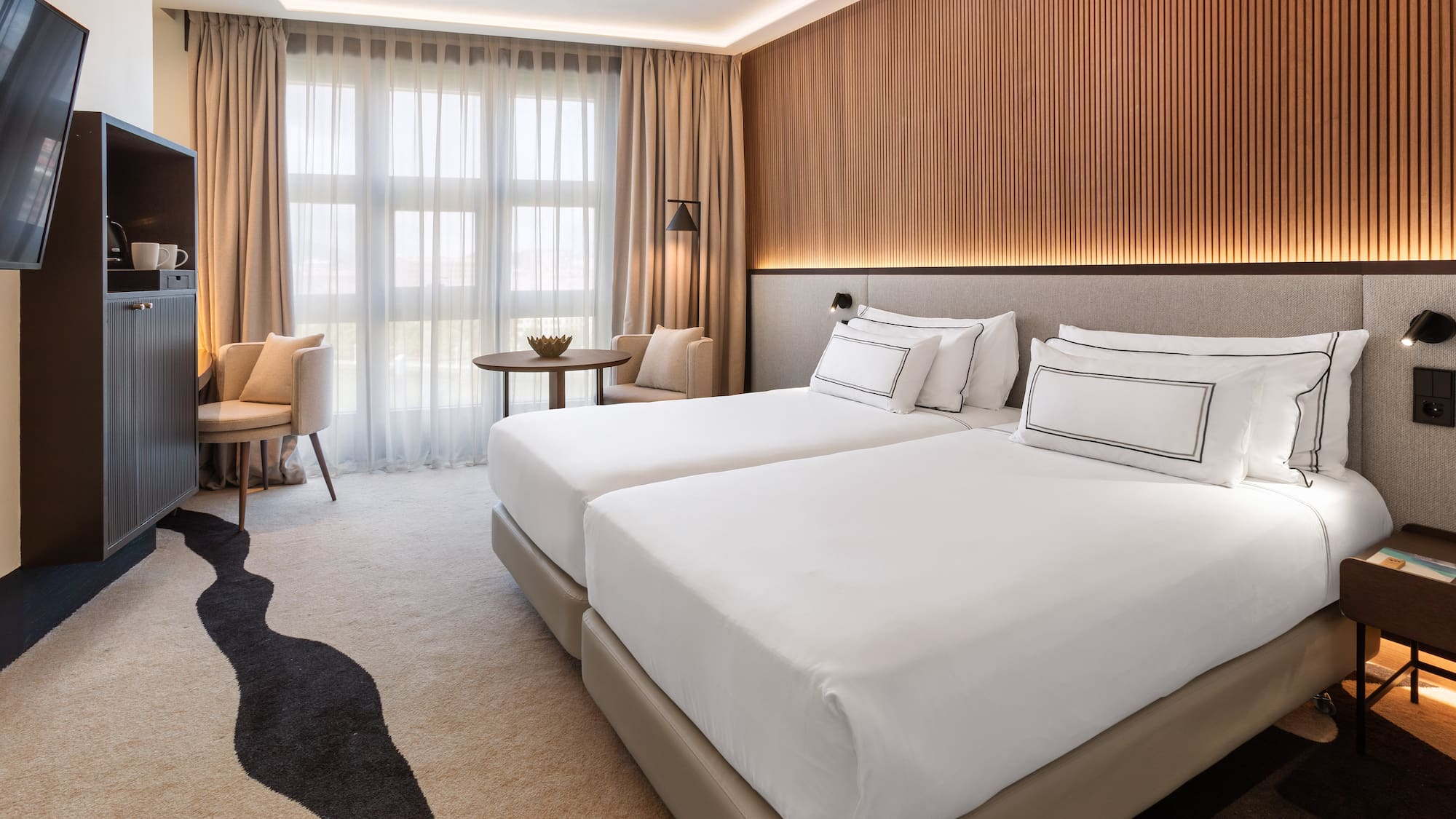 a room with two beds and a table and chairs