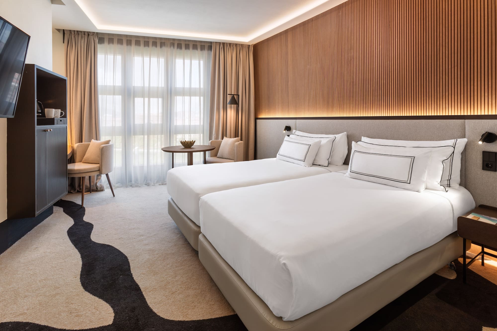 a room with two beds and a table and chairs