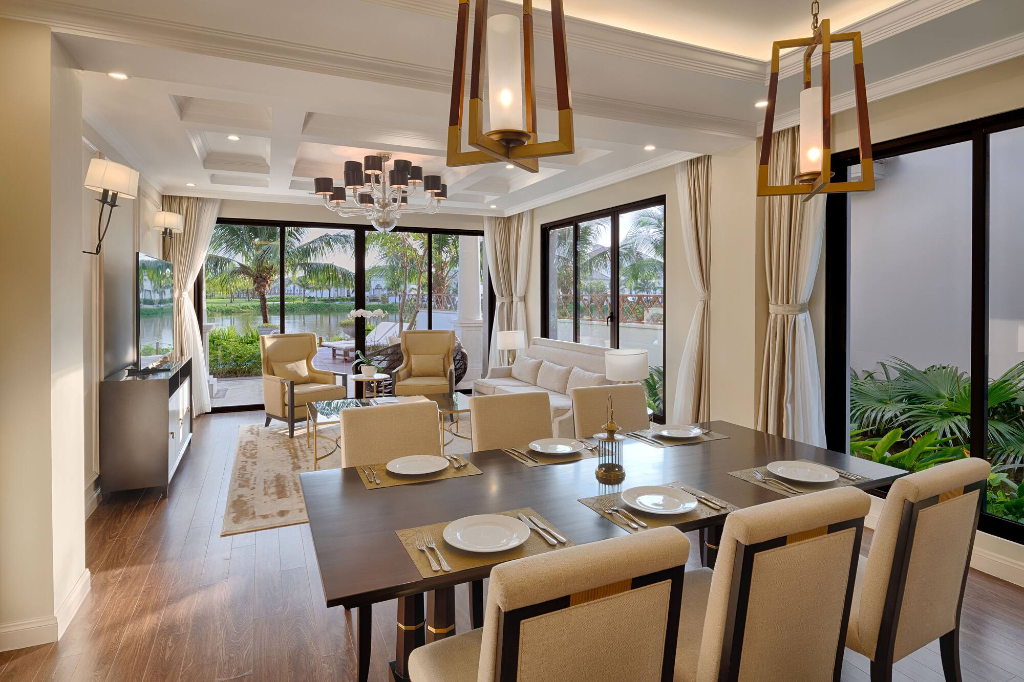 Modern open-plan dining and living area with tropical lake views.