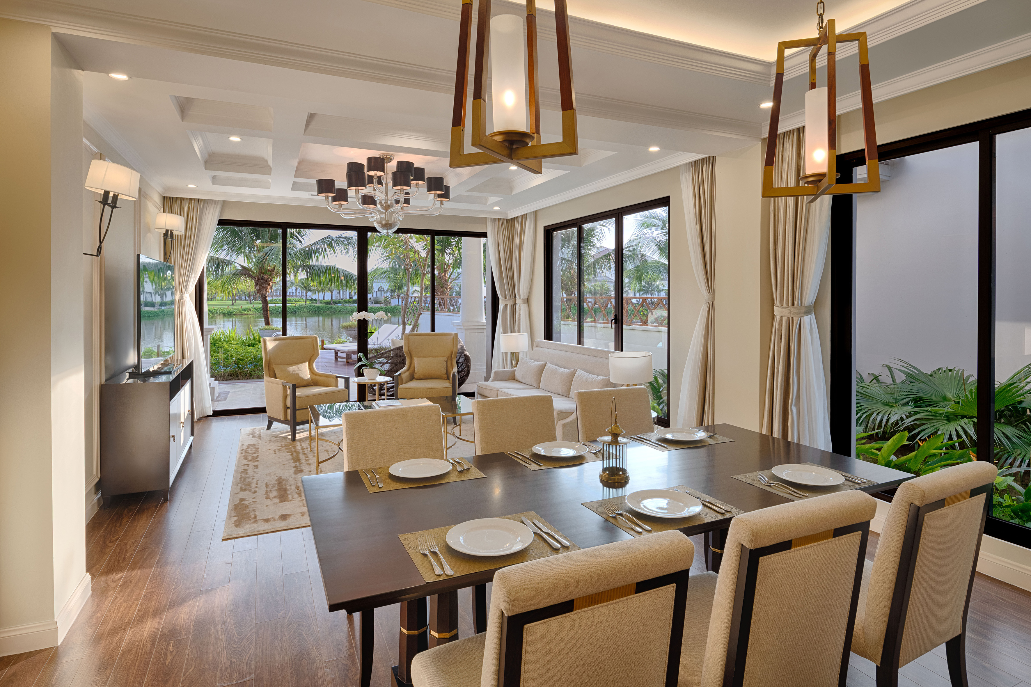 Modern open-plan dining and living area with tropical lake views.
