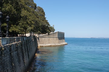 a stone wall next to a body of water