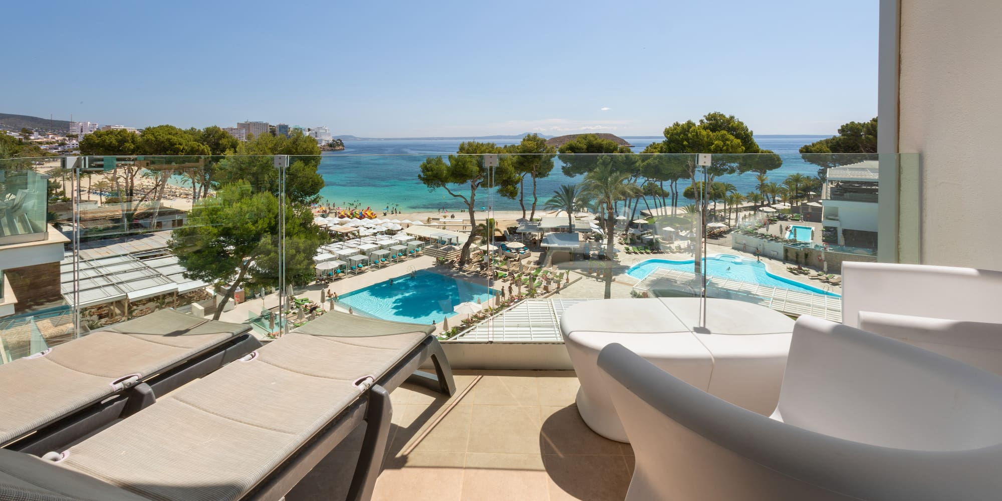 a deck with chairs and a pool overlooking a beach