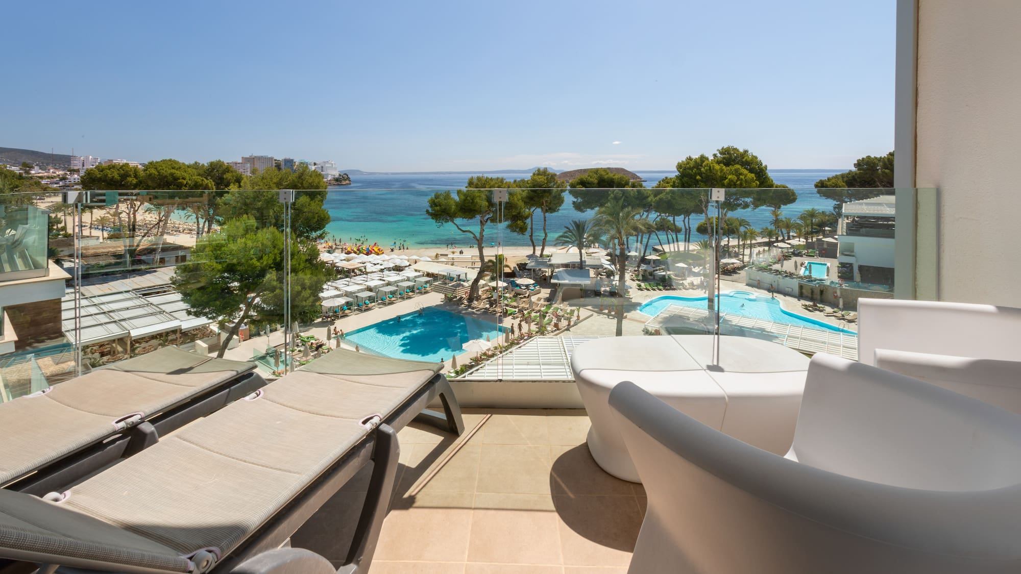 a deck with chairs and a pool overlooking a beach