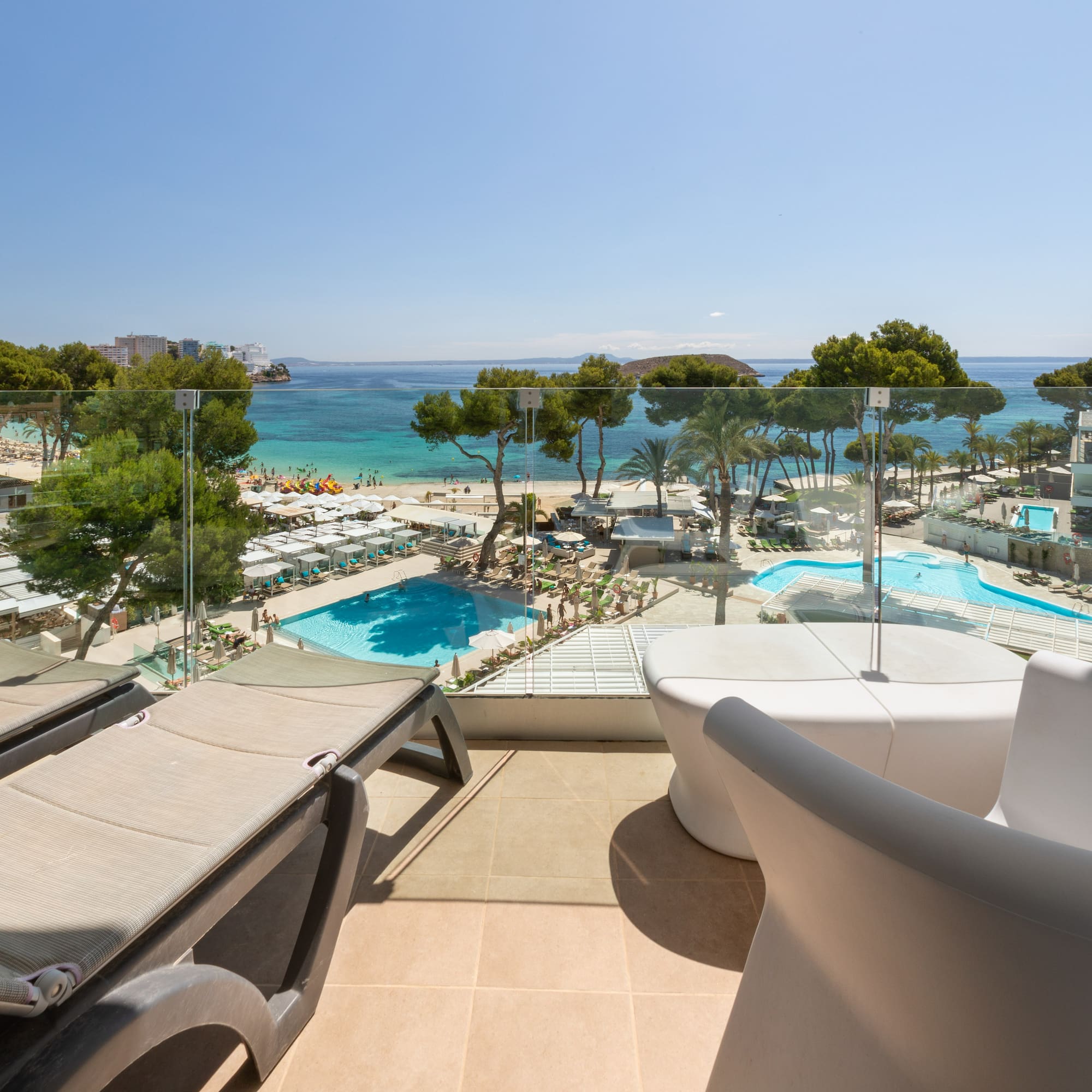 a deck with chairs and a pool overlooking a beach