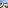 Sunny hotel balcony overlooking a sandy beach, blue ocean, and resort swimming pools.
