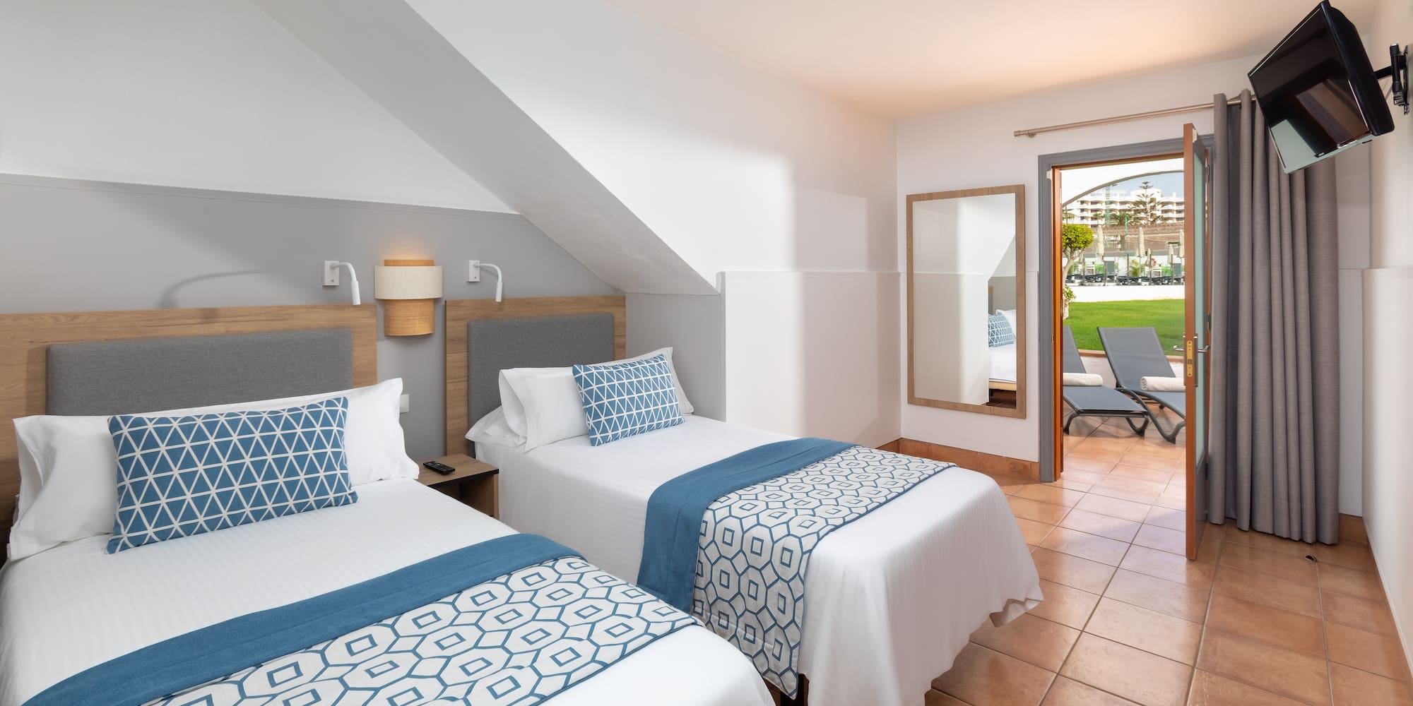 a room with two beds and a patio door