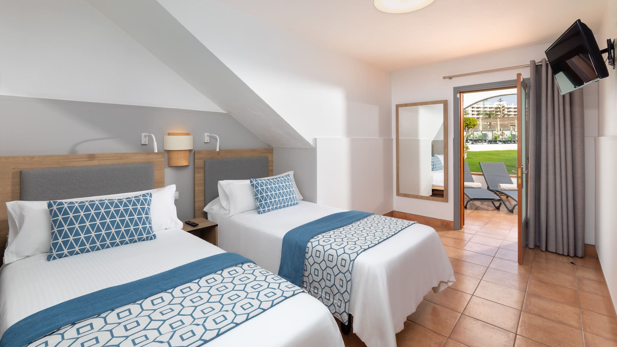 a room with two beds and a patio door