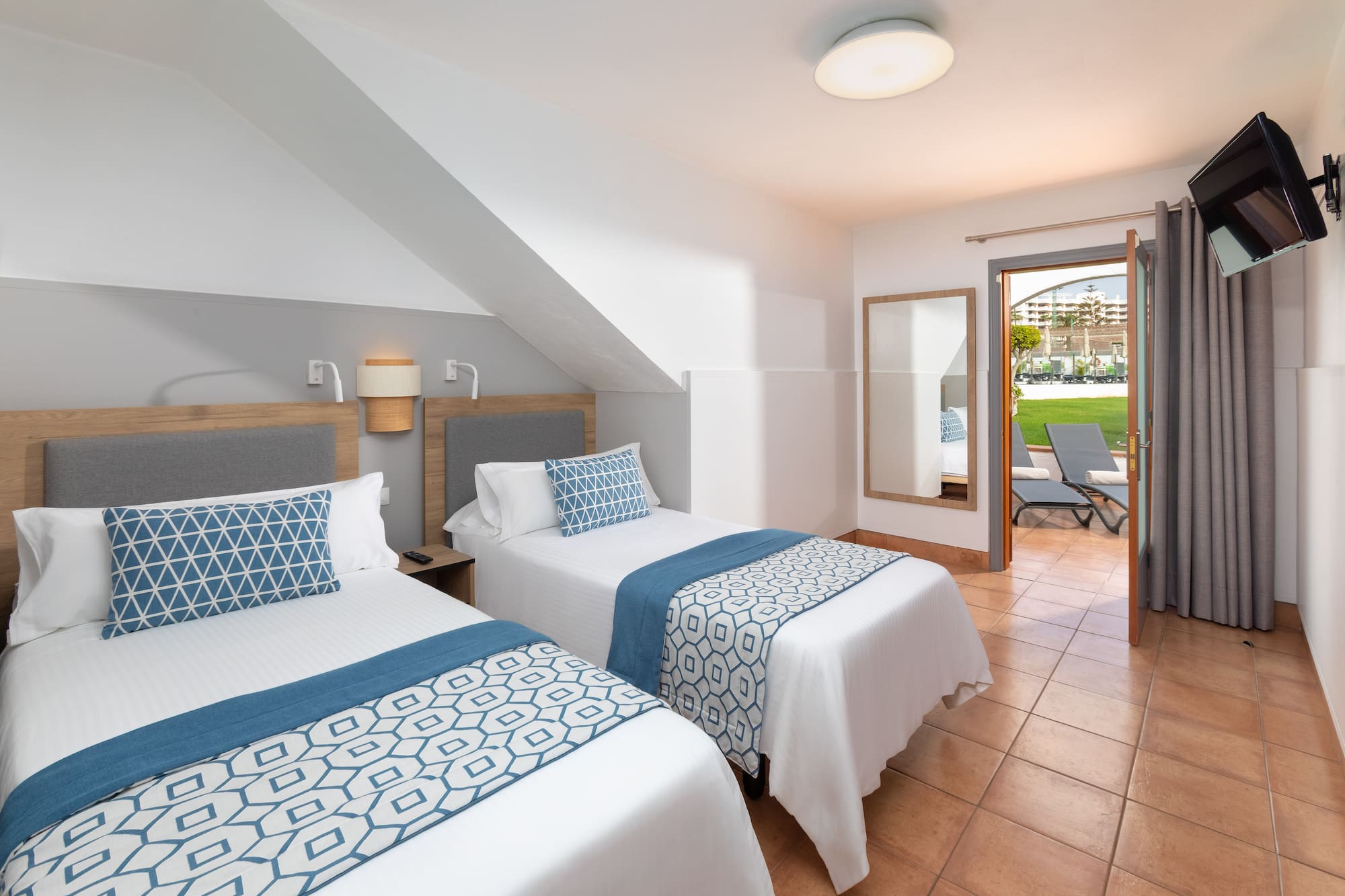 a room with two beds and a patio door