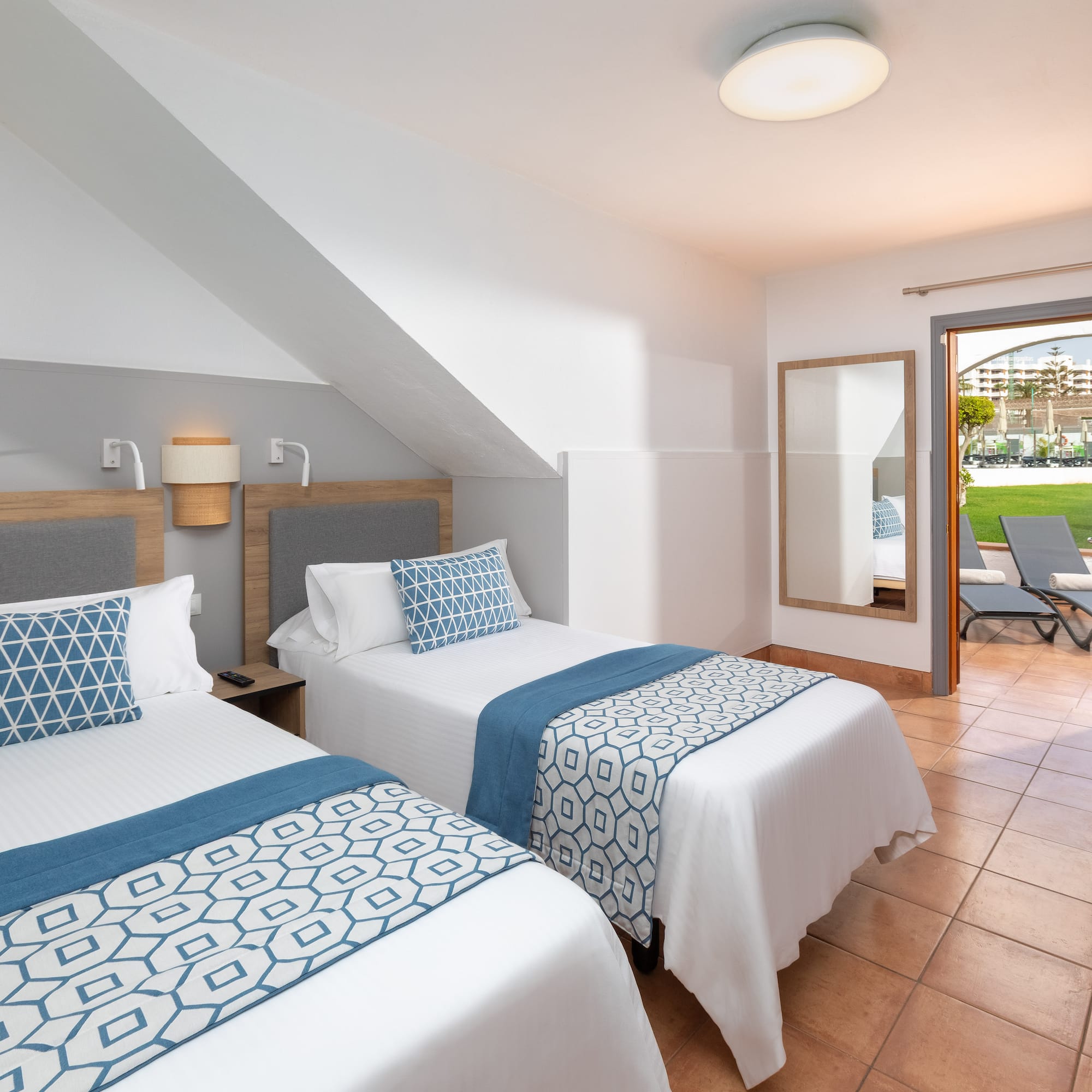 a room with two beds and a patio door