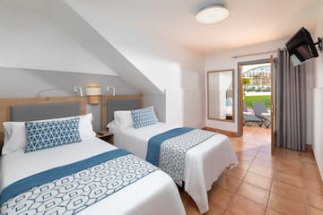 a room with two beds and a patio door