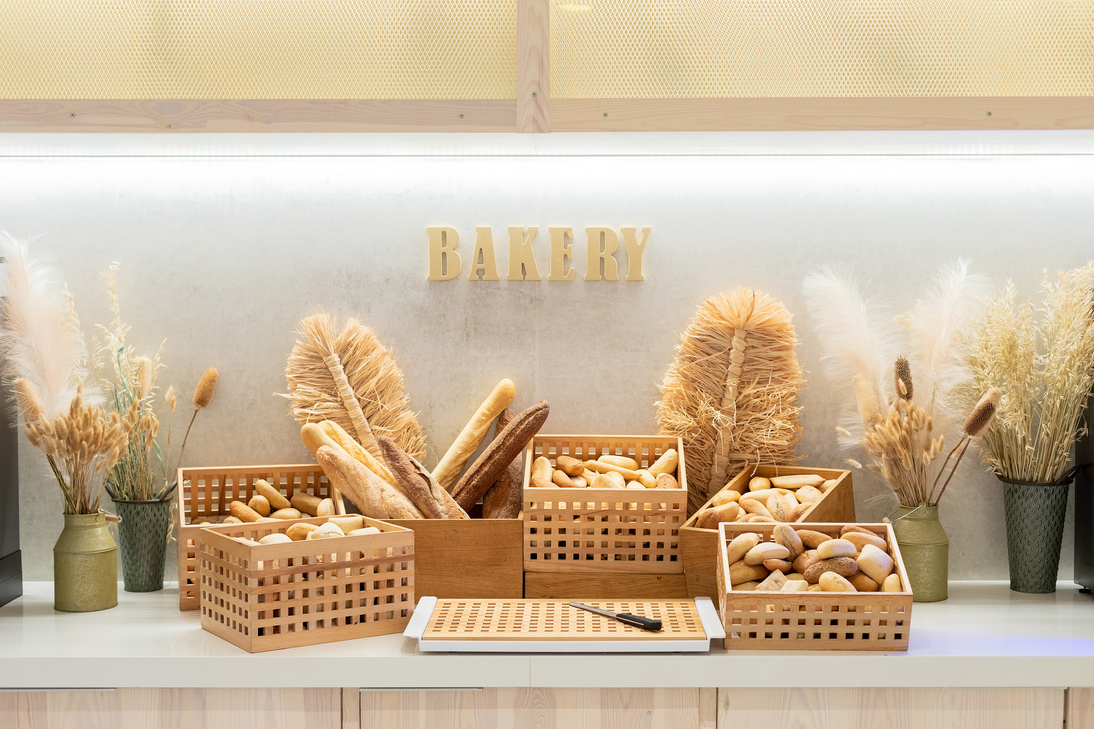 Bakery buffet with fresh baguettes and bread rolls in wooden crates.