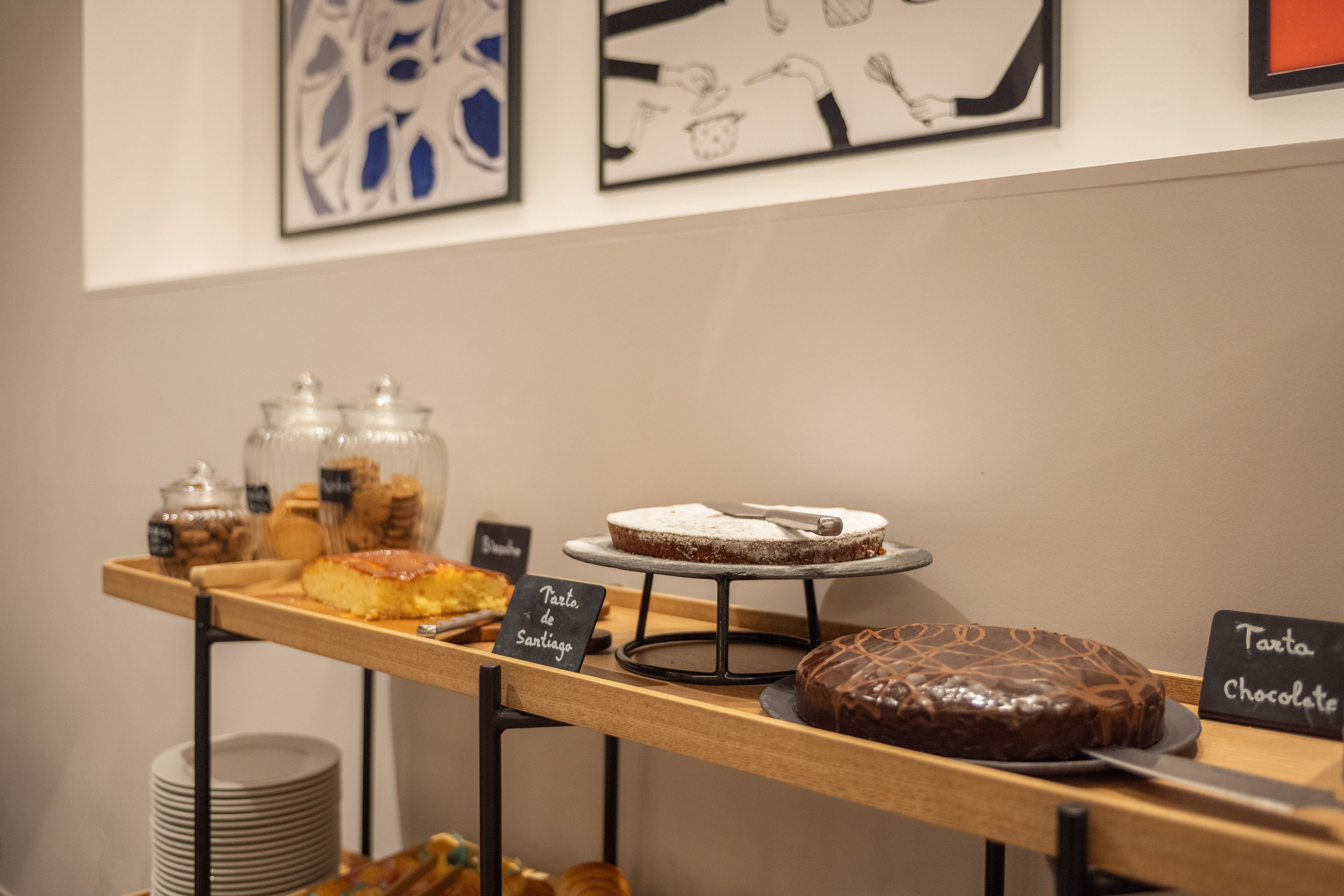Buffet display with Tarta de Santiago, chocolate cake, and cookie jars.