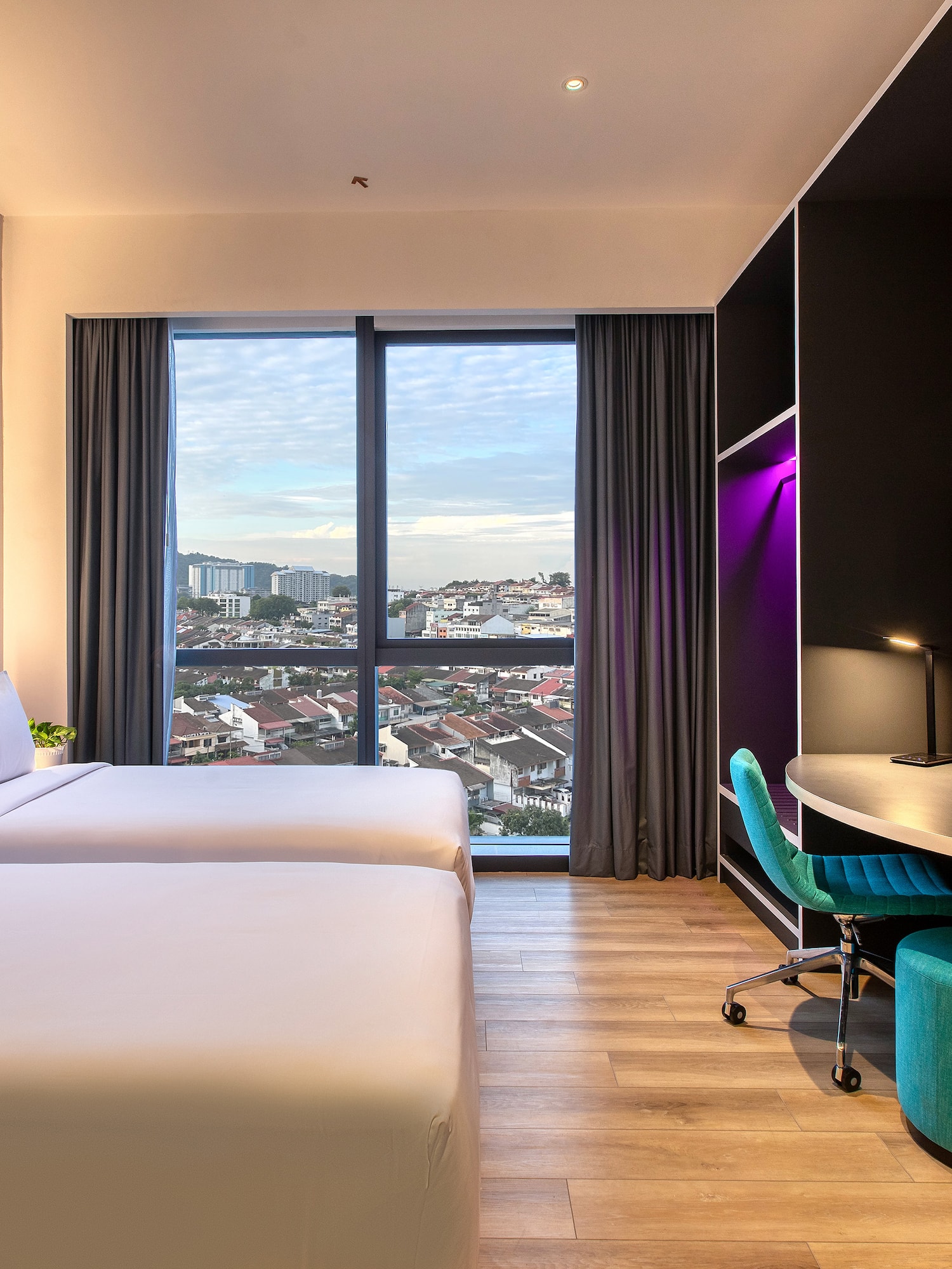 a room with two beds and a desk and a window