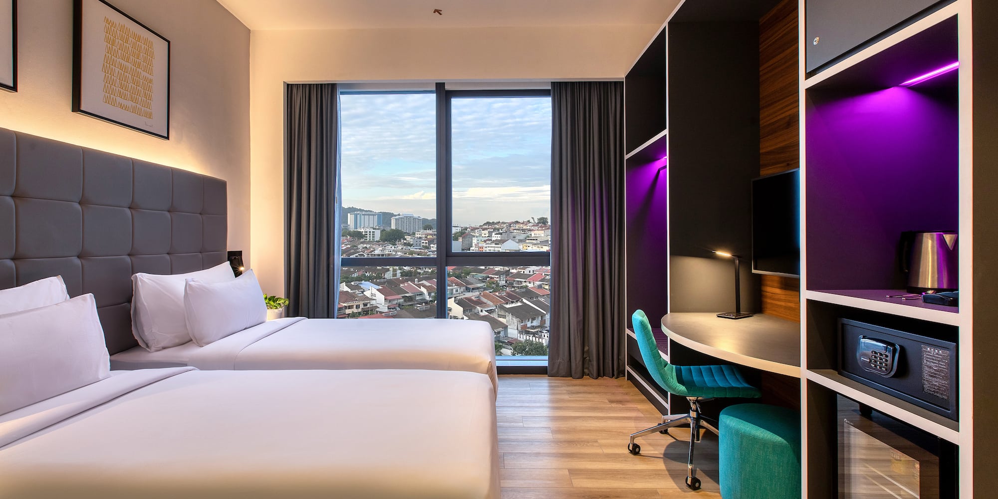 a room with two beds and a desk and a window