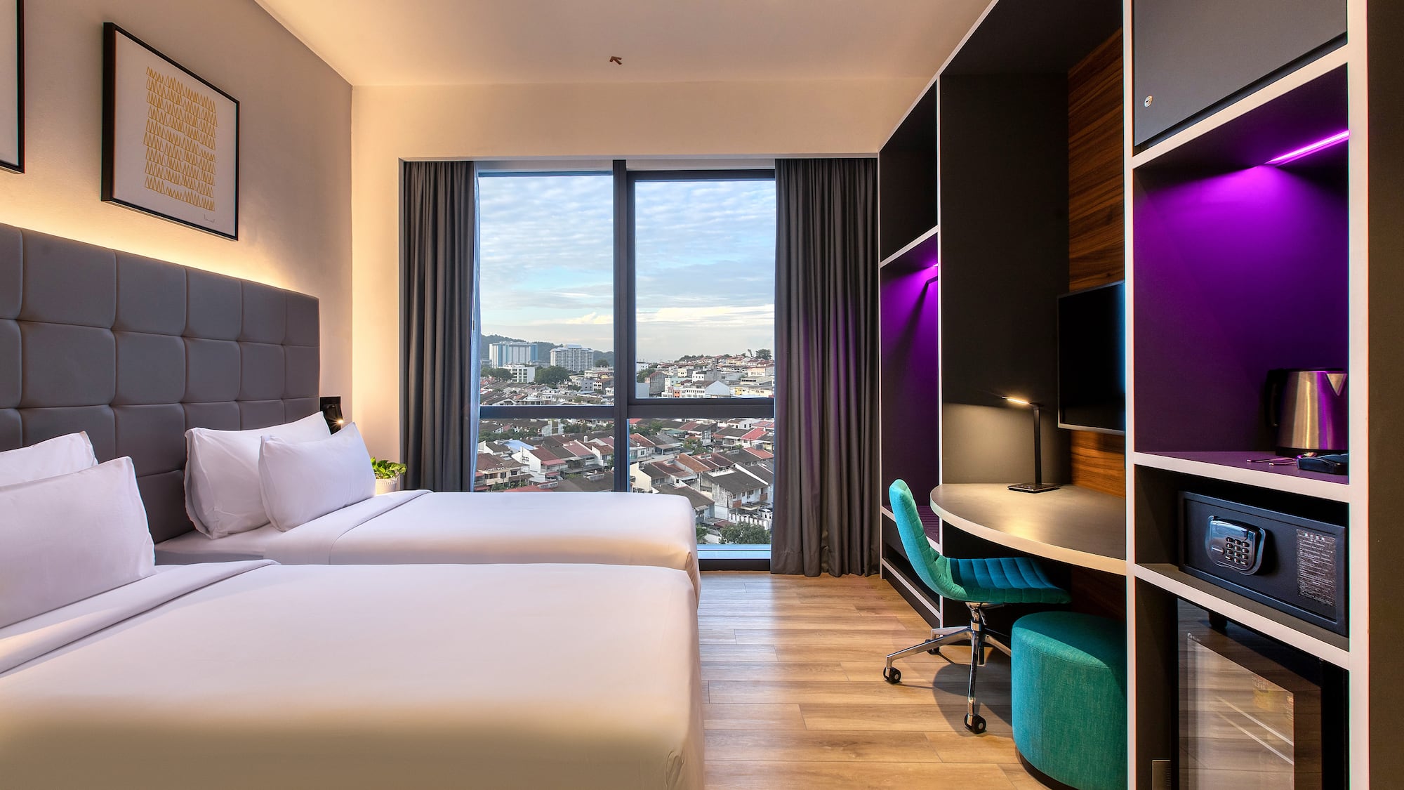 a room with two beds and a desk and a window