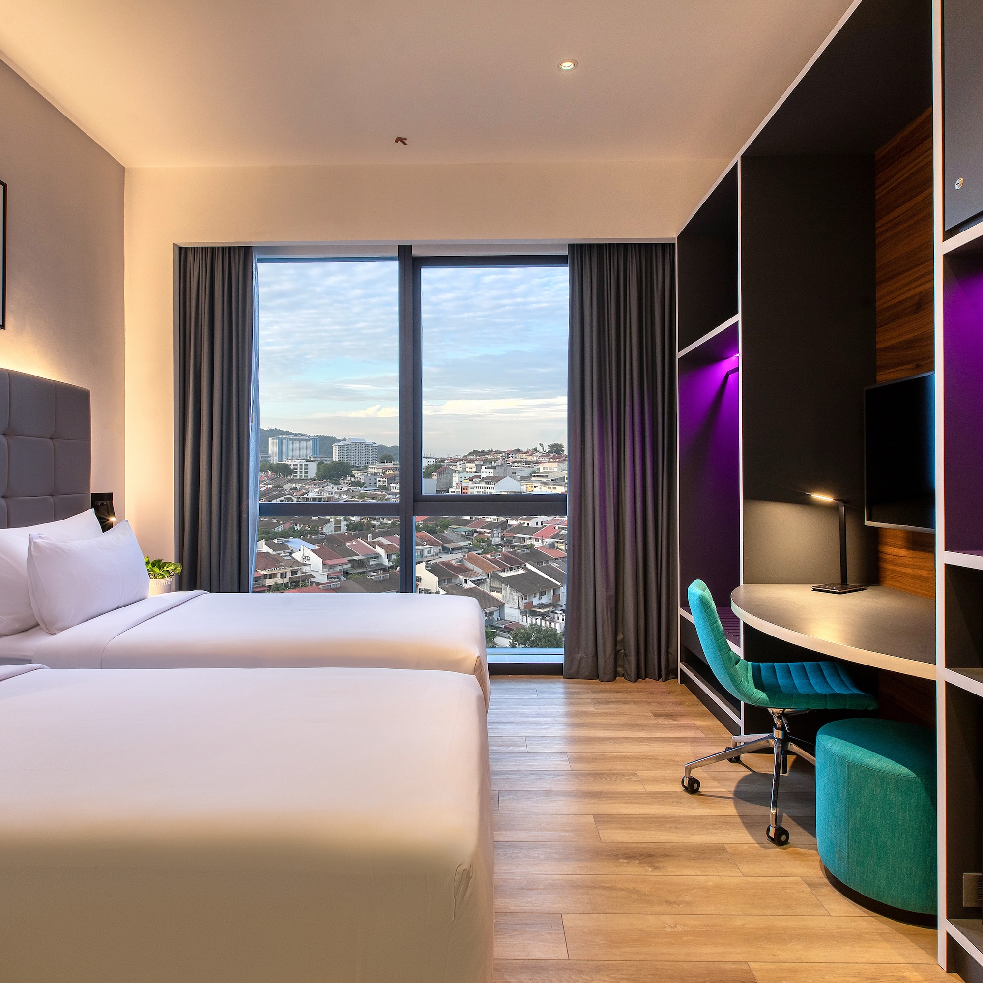 a room with two beds and a desk and a window