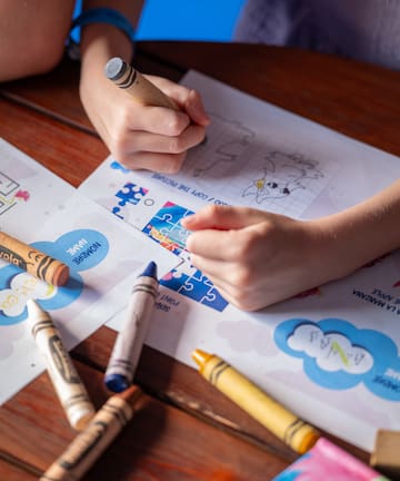 a child coloring on a piece of paper