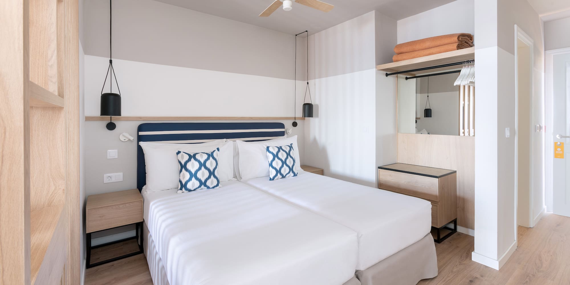 a room with two beds and a ceiling fan