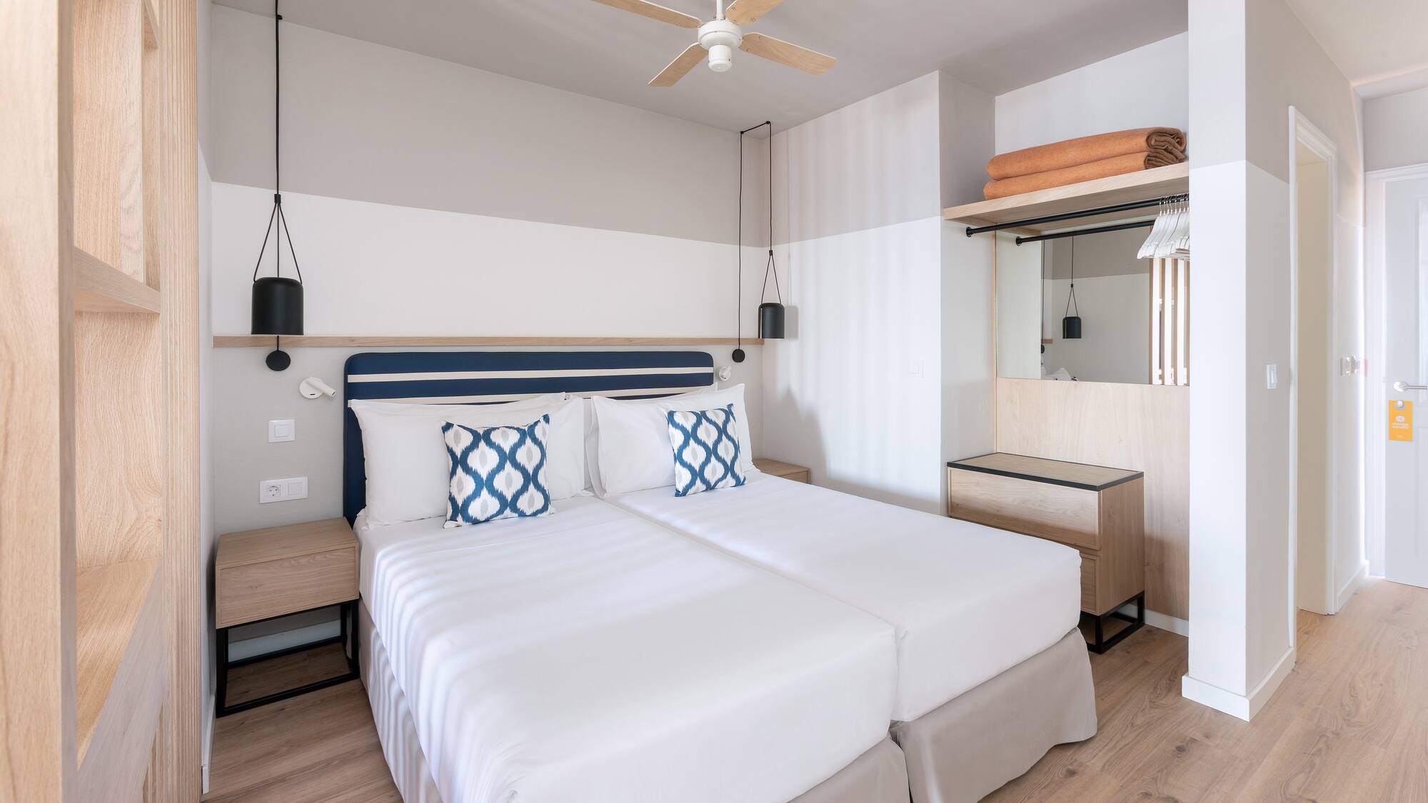 a room with two beds and a ceiling fan