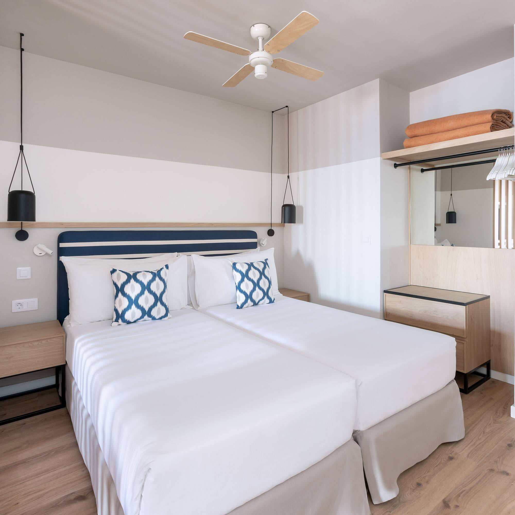 a room with two beds and a ceiling fan