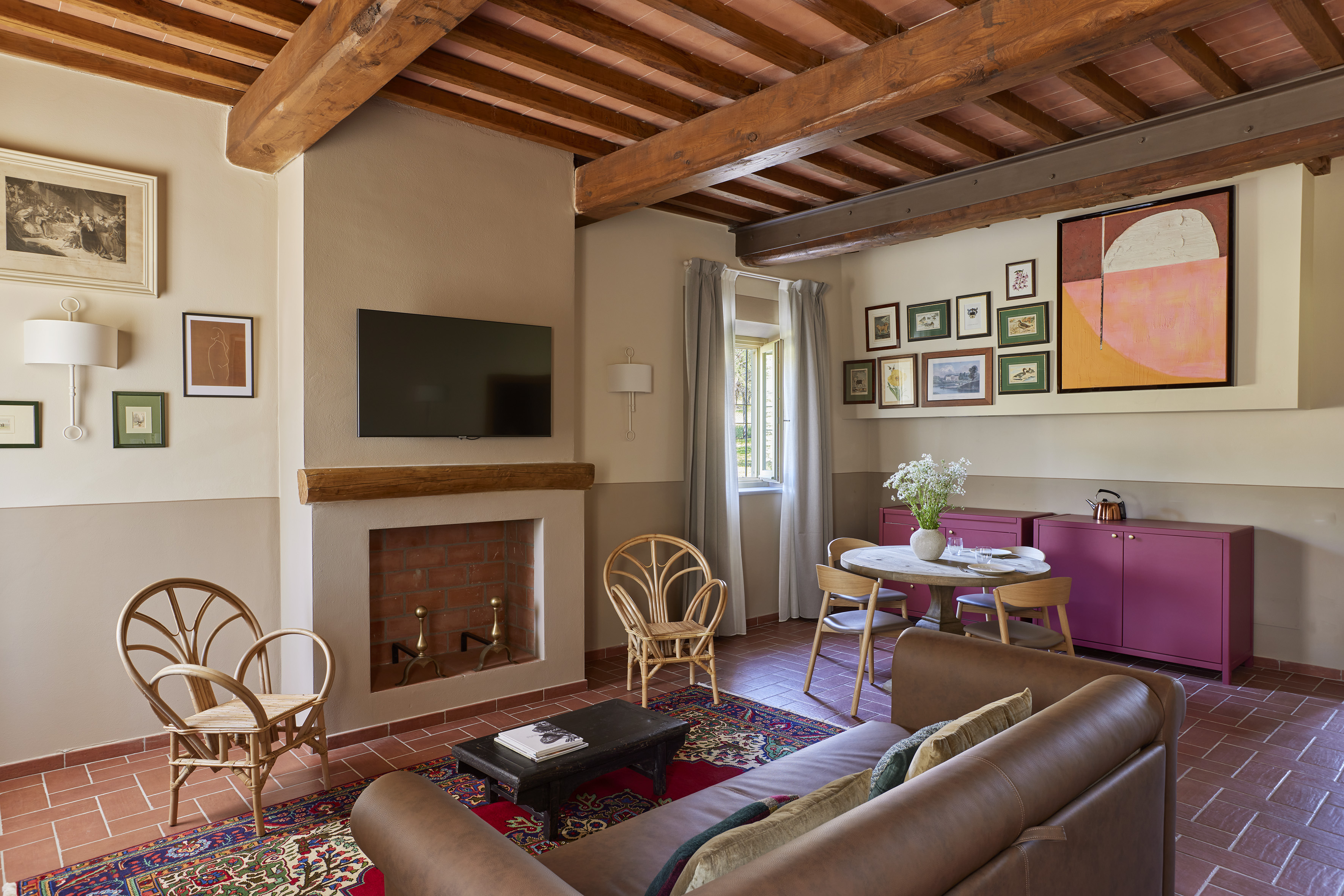 Tuscan living dining room, exposed beams, terracotta floor, leather sofa.