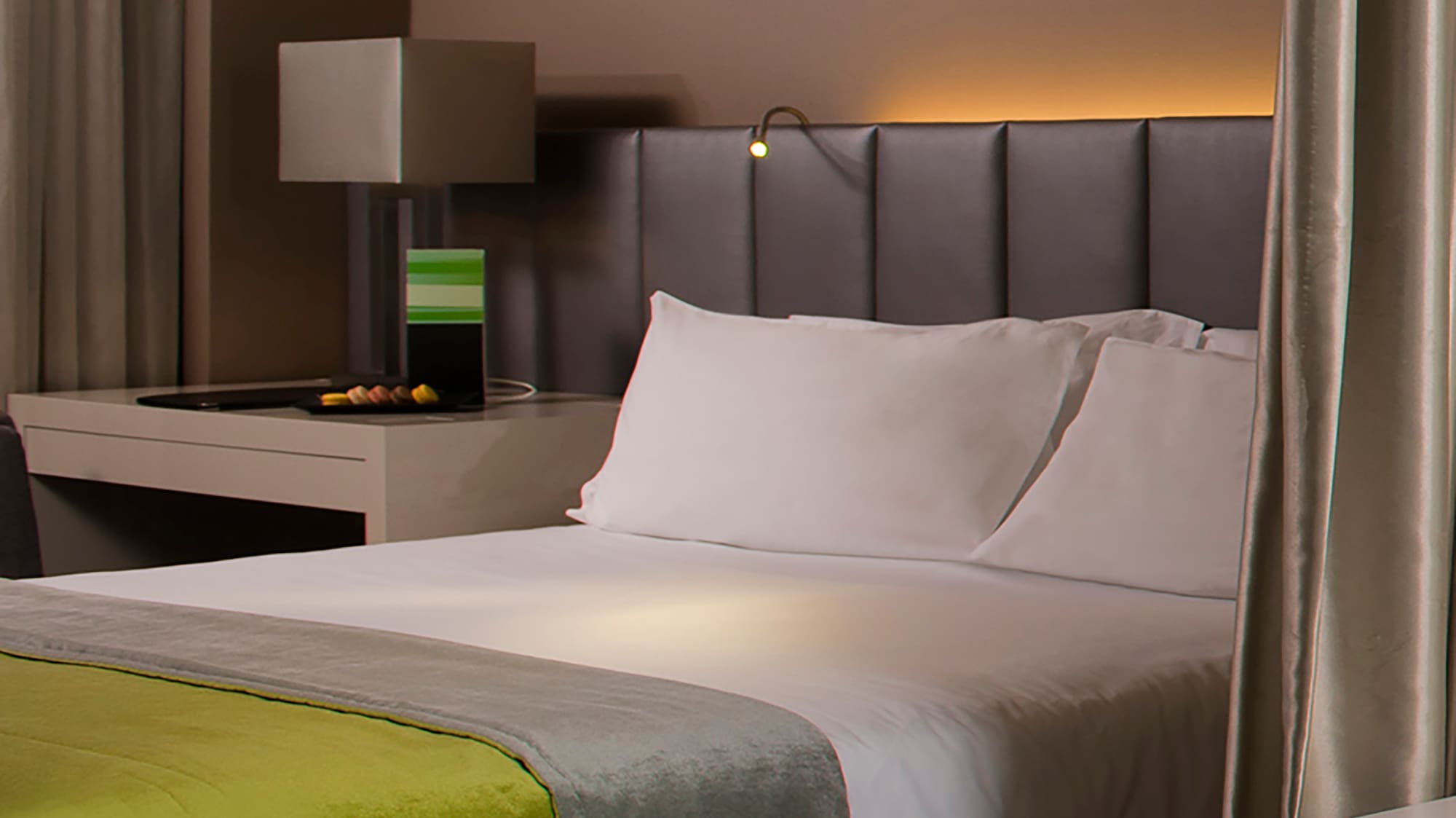 a bed with a green blanket and a white bathtub