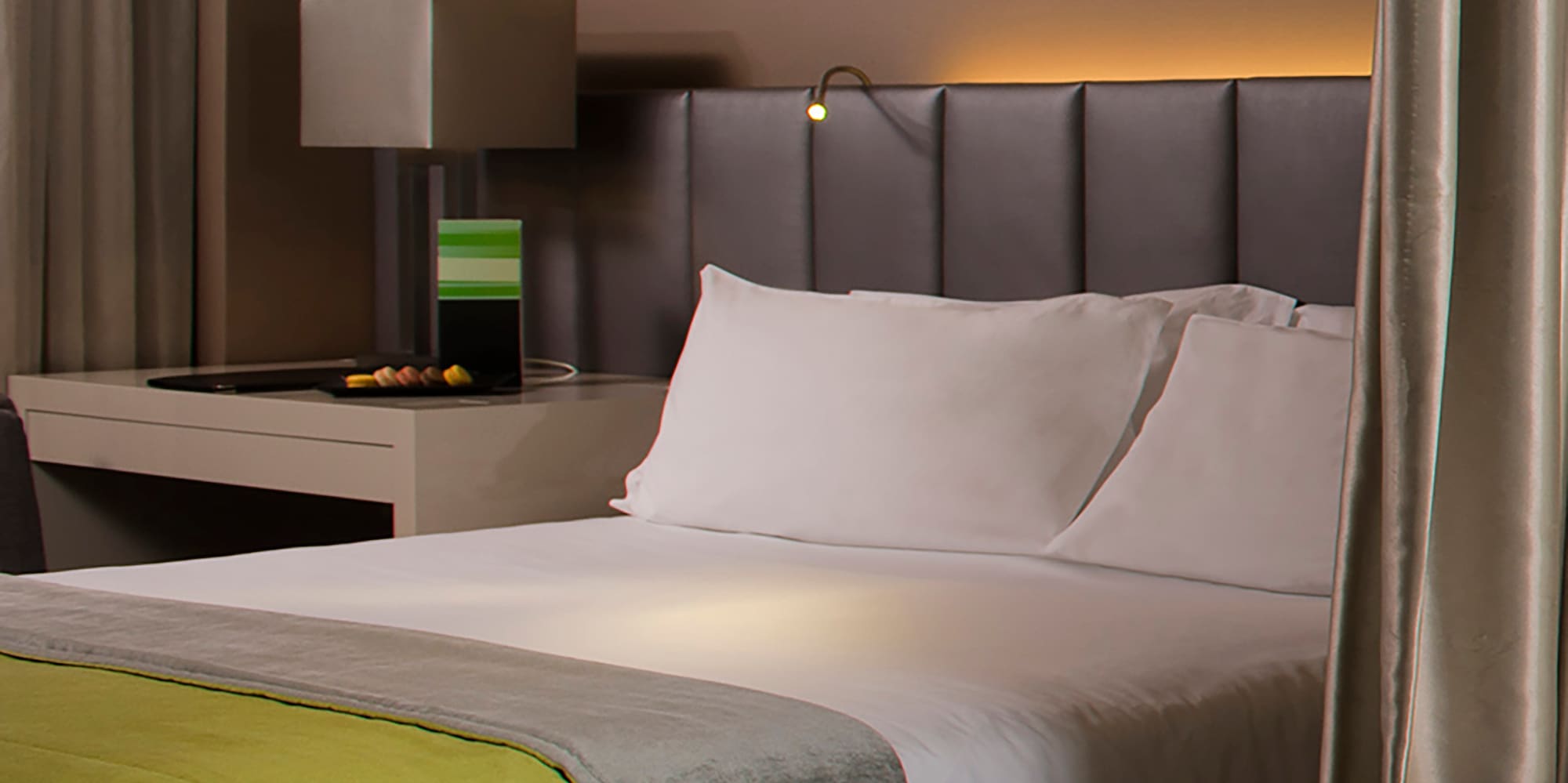 a bed with a green blanket and a white bathtub