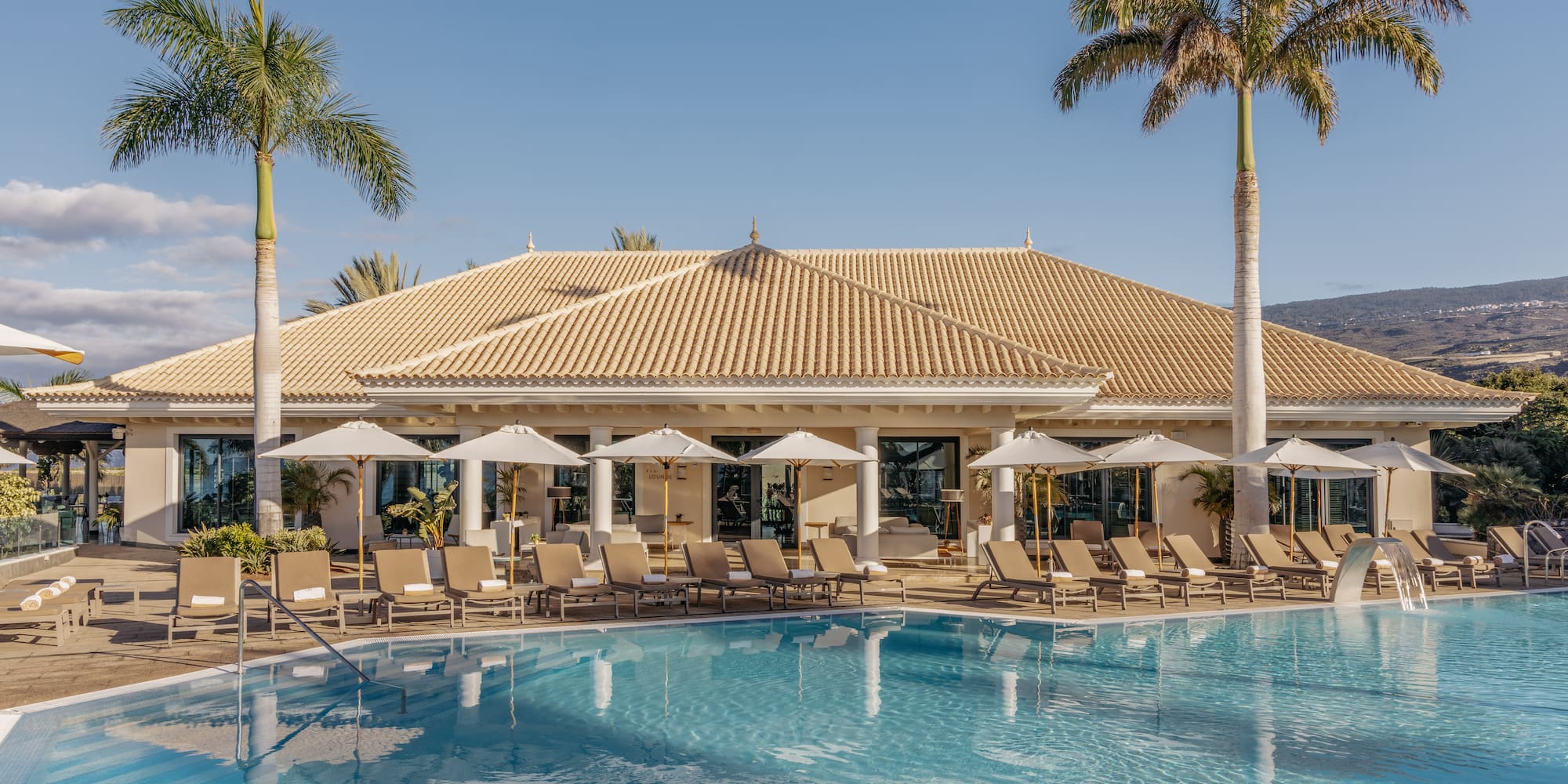 a pool with lounge chairs and palm trees