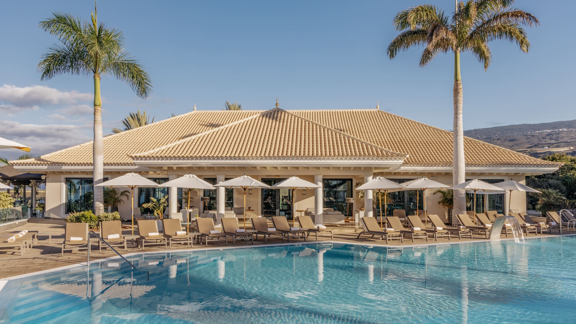 a pool with lounge chairs and palm trees