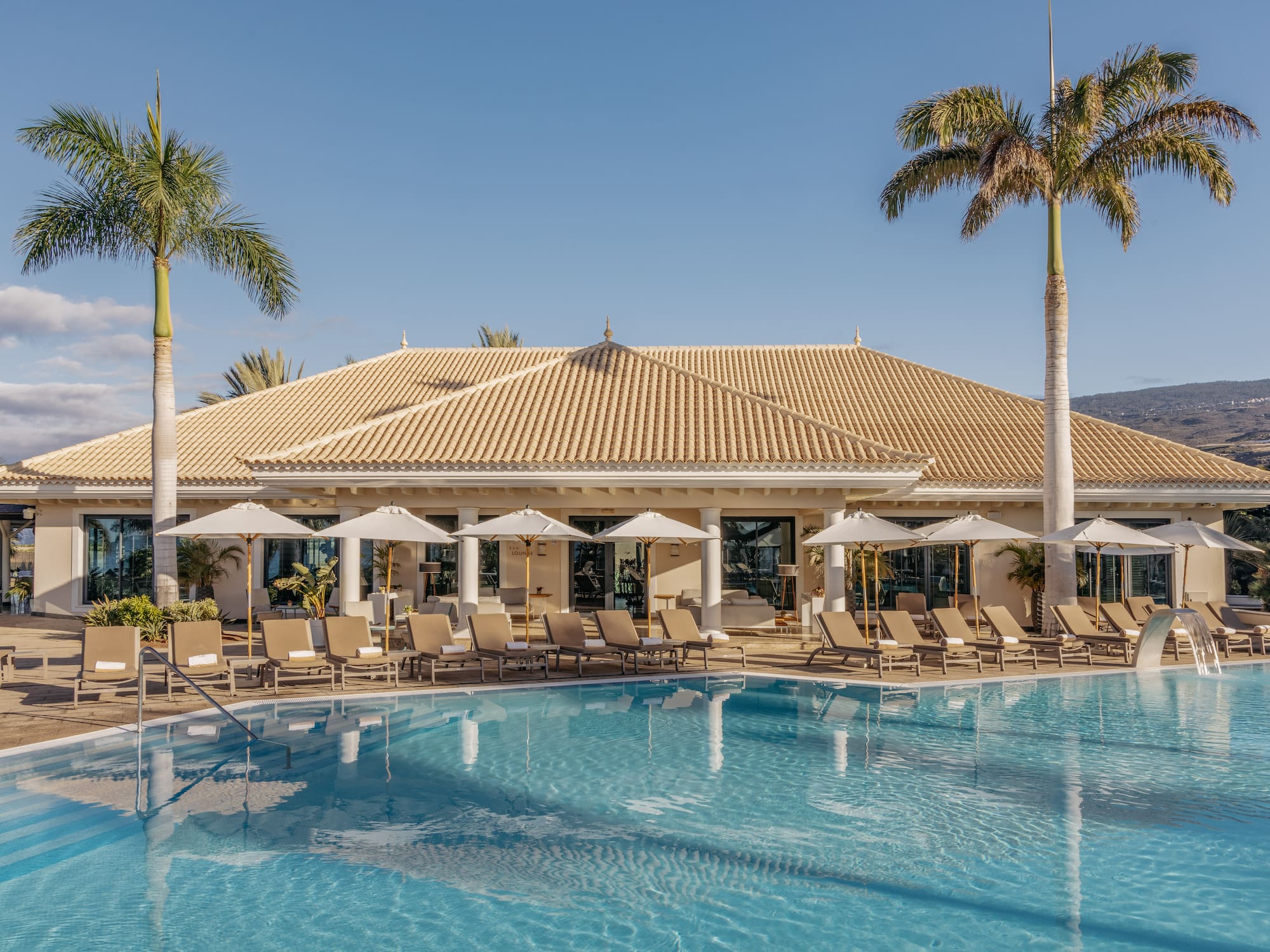 a pool with lounge chairs and palm trees