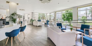 a room with white furniture and blue chairs