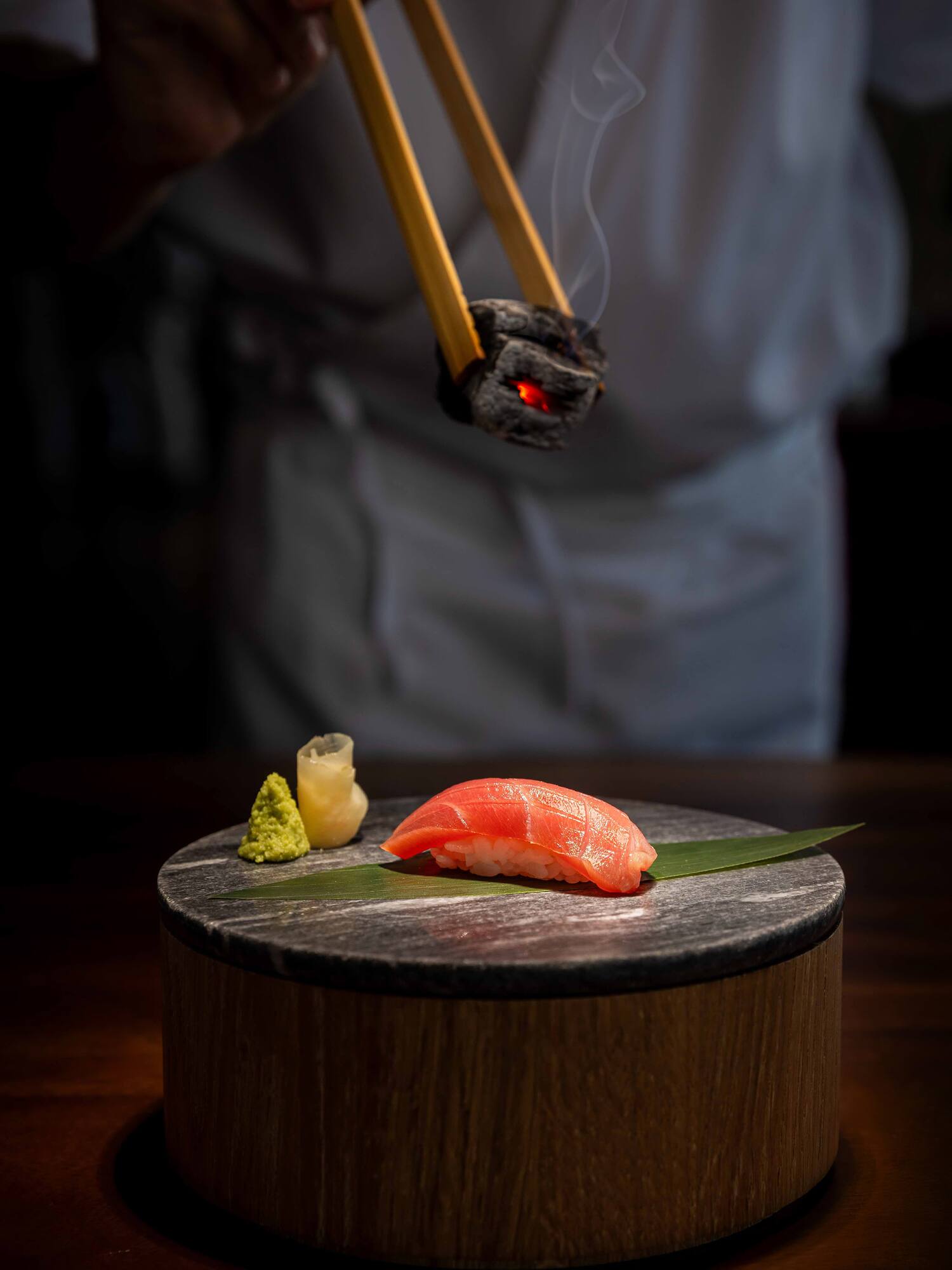 a chopsticks holding a piece of sushi