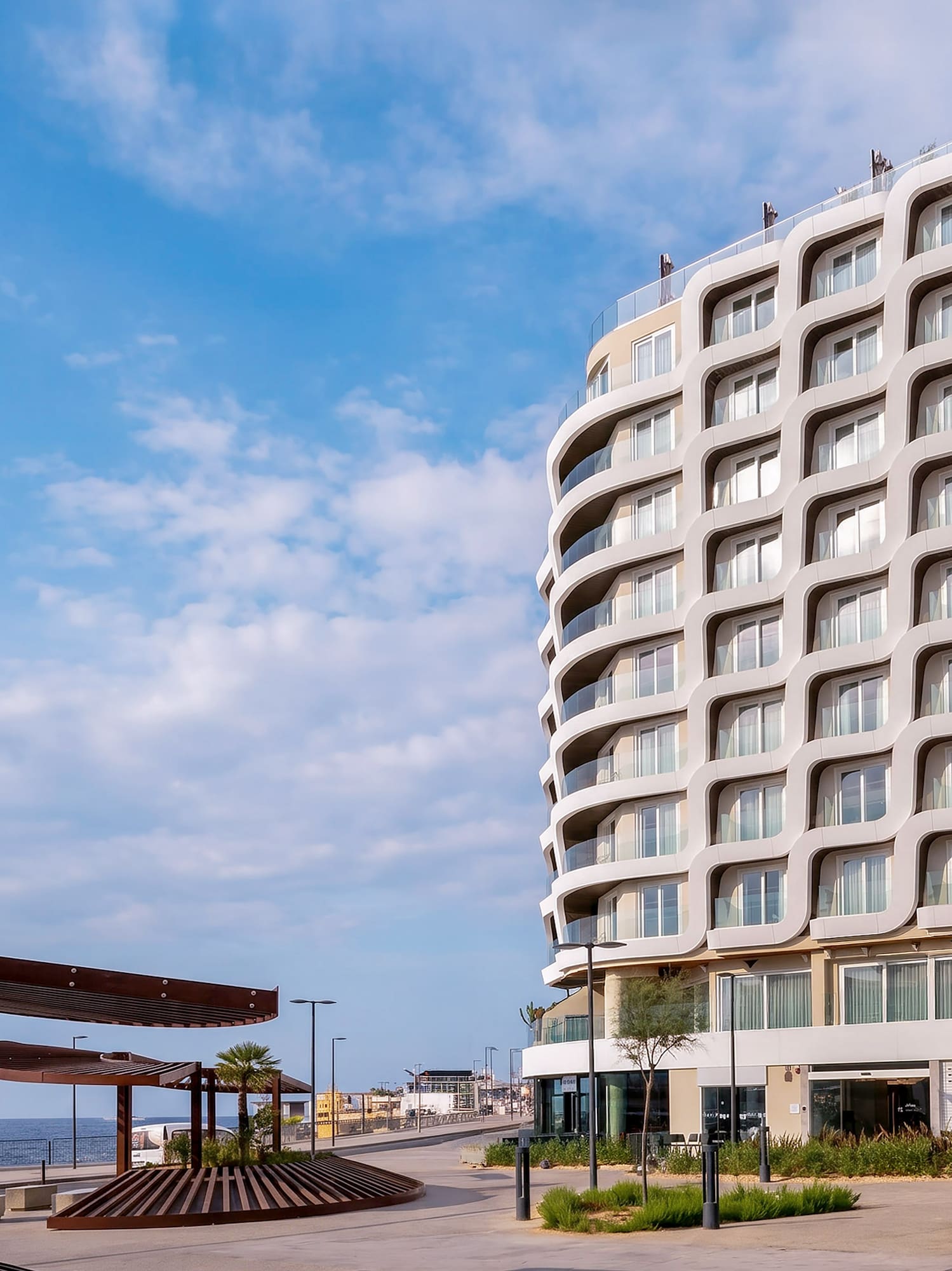 INN SIDE modern hotel with wavy facade on coastal promenade.