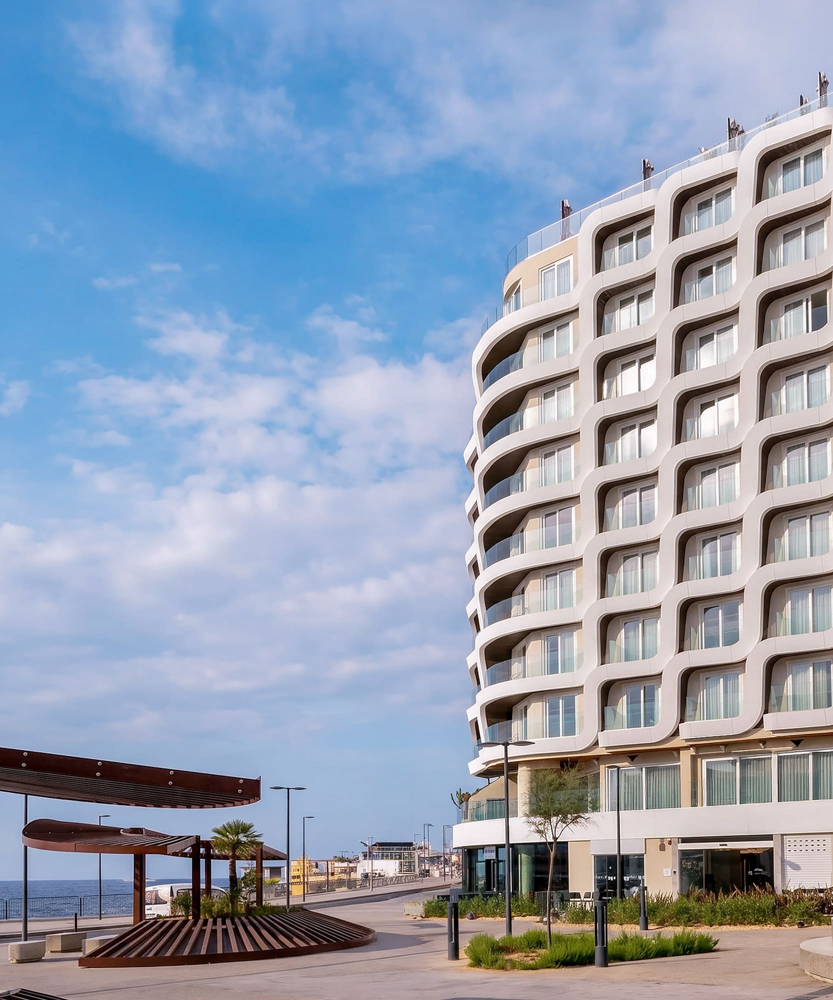 INN SIDE modern hotel with wavy facade on coastal promenade.