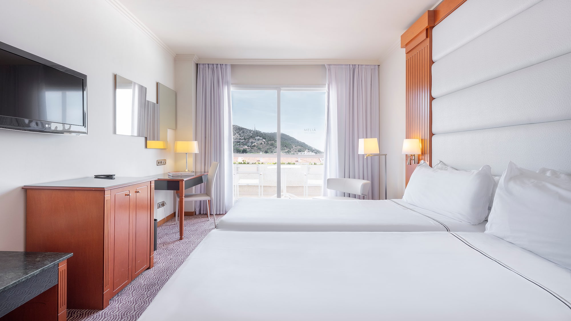 a room with two beds and a television